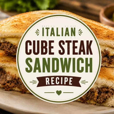 Italian cube steak sandwich with melted cheese on toasted bread featured on a rustic background with title graphic overlay