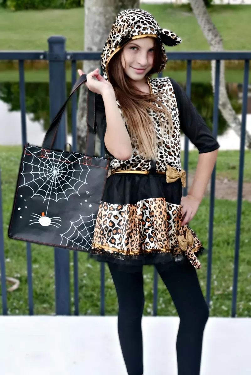 Girl wearing a leopard Halloween costume and holding a spiderweb trick-or-treat bag