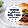 Hand-shaped black bean burger with lettuce, pickles, red onion, and mustard on a white plate.