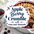 Apple berry crumble topped with golden oats and sliced almonds in a white baking dish