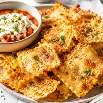 Crispy Parmesan garlic lasagna chips served on a platter with marinara ricotta dip, fresh parsley, and Italian herbs.