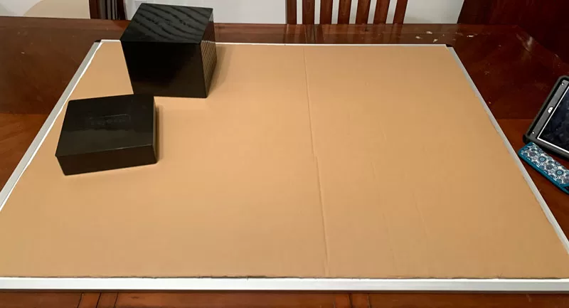 Large puzzle board covered with cardboard packaging to protect the puzzle underneath.