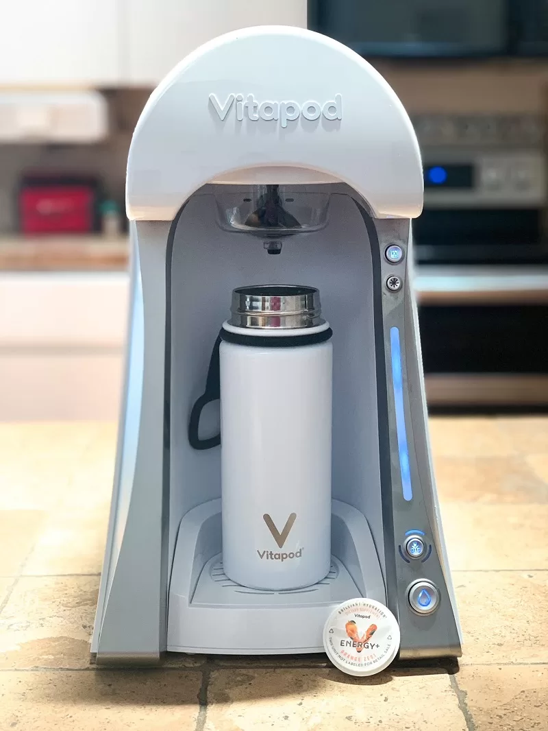 White Vitapod machine with reusable bottle and Orange Zest Energy+ pod