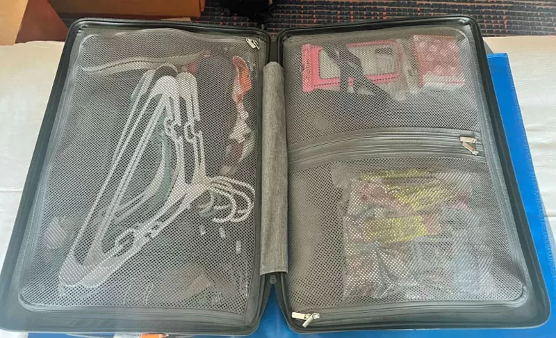 Open LEVEL8 suitcase showing two zippered packing compartments and interior pockets.