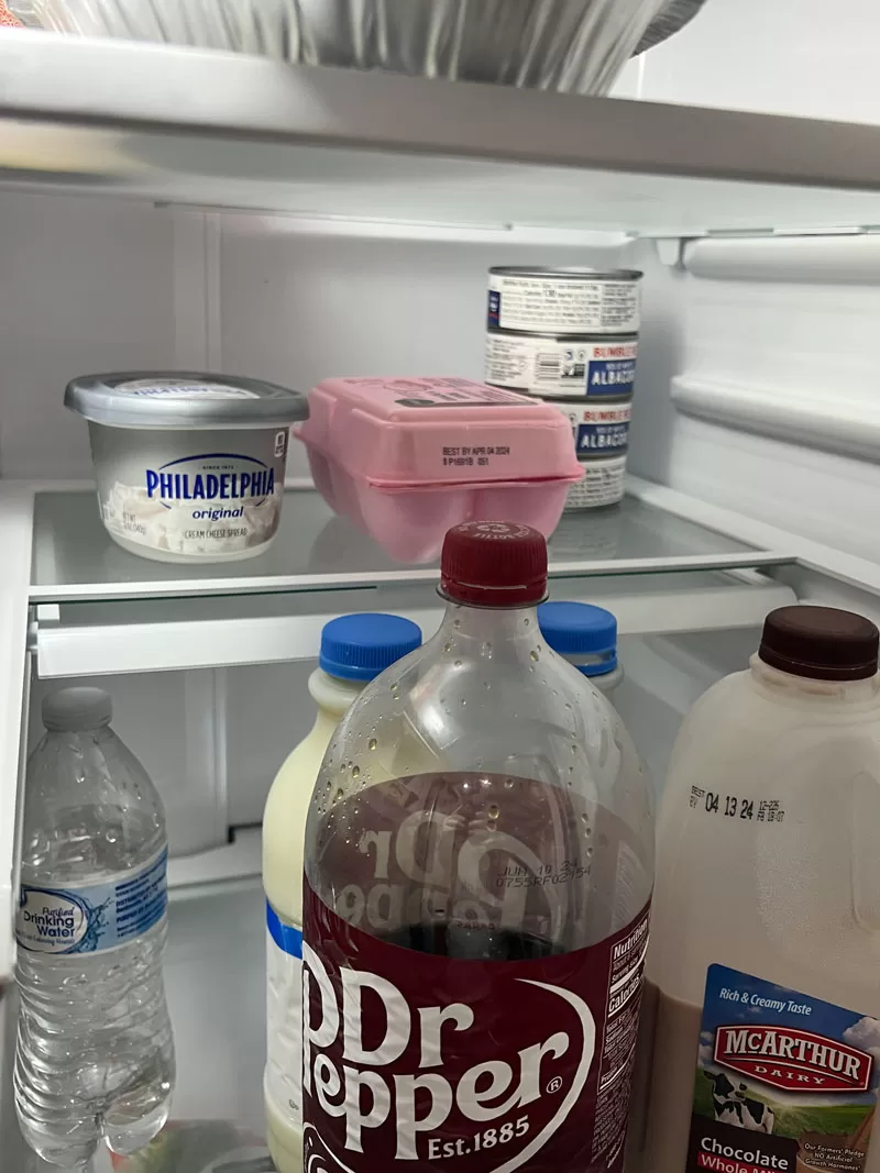 Inside view of GE GFE26JYMFS refrigerator showing adjustable glass shelves and food storage compartments