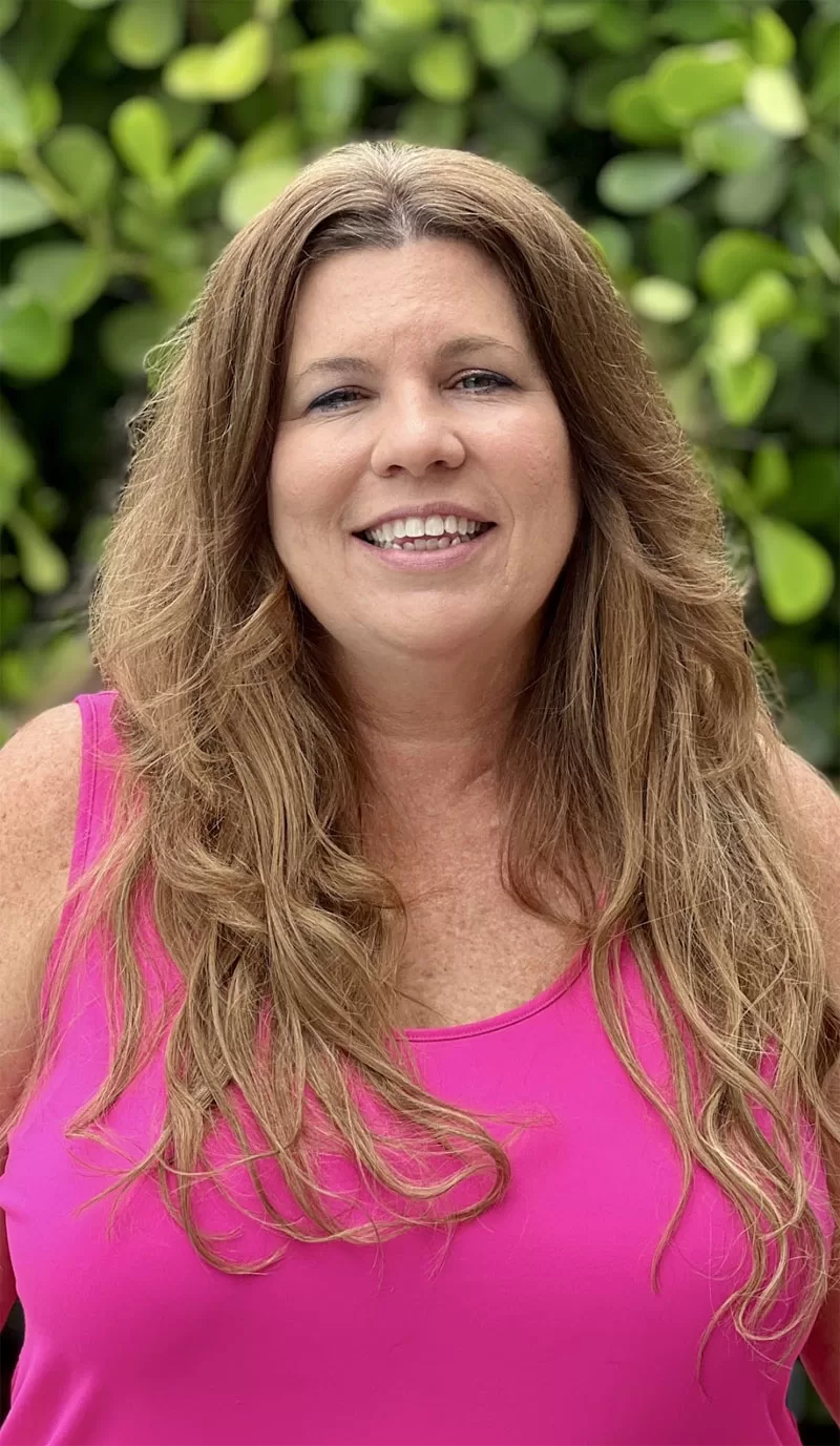 Woman wearing long caramel balayage clip-in hair extensions styled with loose curls.