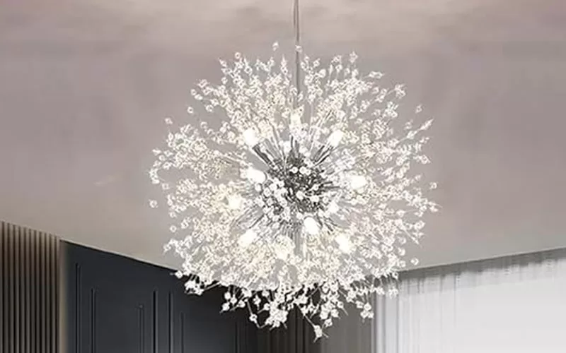 Crystal dandelion chandelier lit above the dining room with bright white bulbs and crystal details.