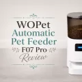 WOPet Automatic Pet Feeder F07 Pro with decorative review title text on a gray wood floor.