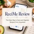 ReciMe review featured image showing a smartphone with the ReciMe app on a kitchen counter surrounded by fresh ingredients and a meal planning notebook.