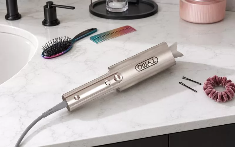 TYMO CURLPRO PLUS automatic curler on a white granite bathroom counter with styling tools.