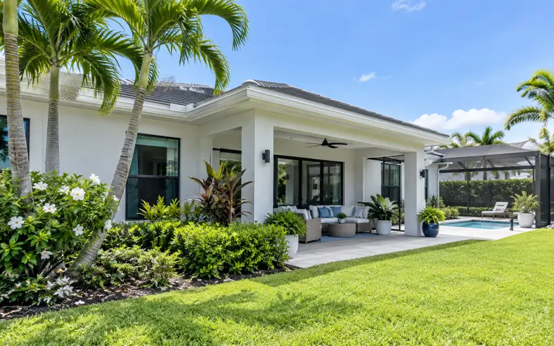 Bright Florida home with a tidy yard, pool, and tropical landscaping