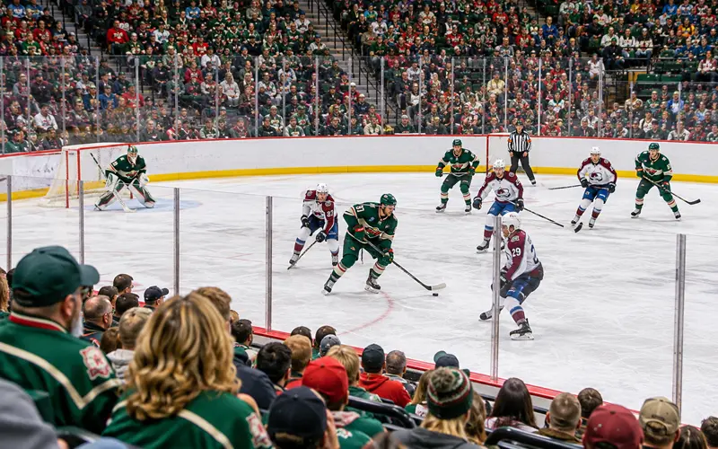 Minnesota Wild hockey players competing against the Colorado Avalanche as fans watch from the stands at Grand Casino Arena in St. Paul.